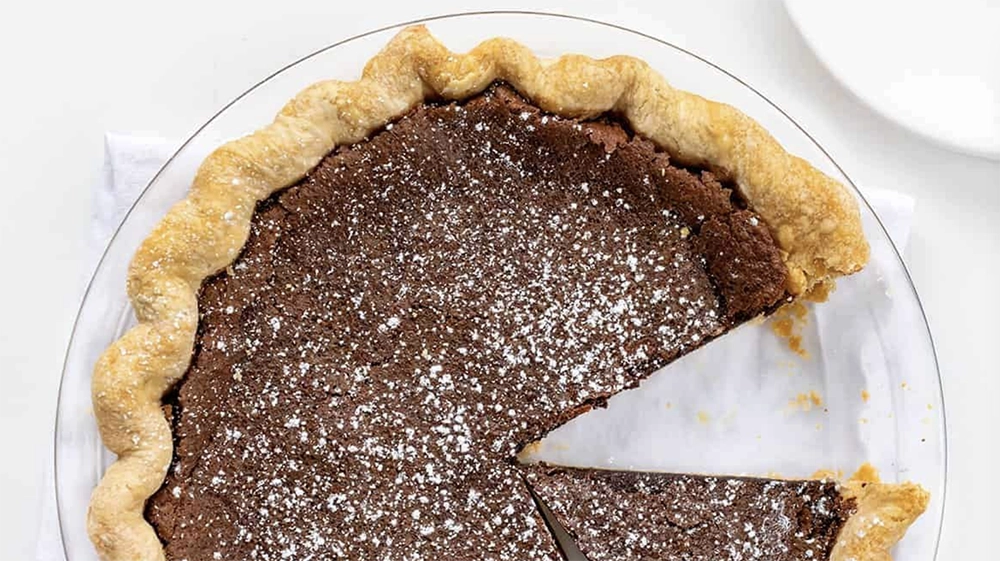 Spreading marshmallow fluff on a homemade choco pie layer.