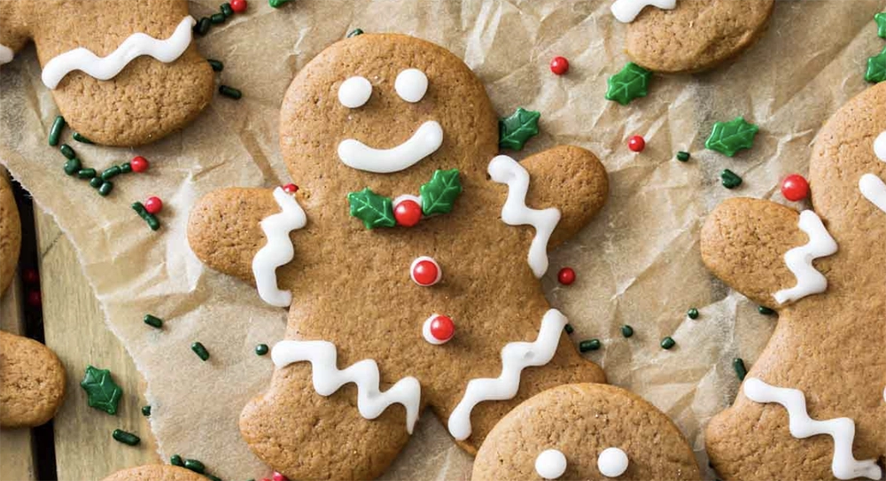 Decorated gingerbread men Christmas cookies with icing and candies on a holiday plate.