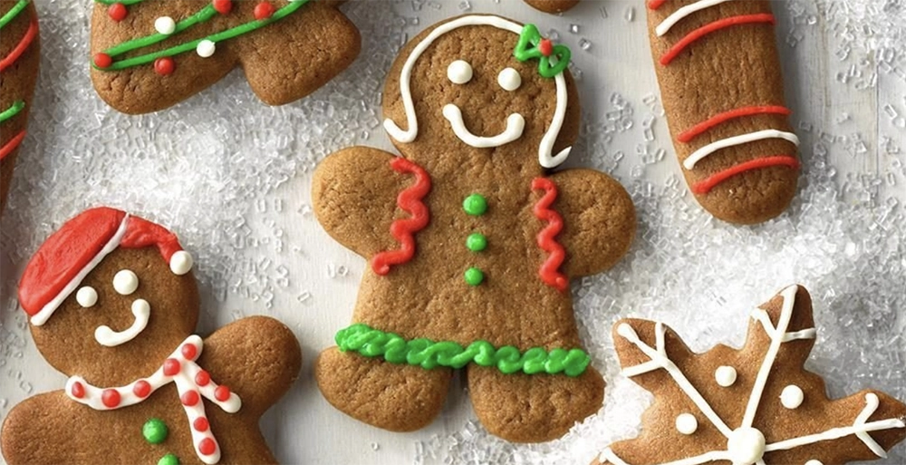 Decorated gingerbread men Christmas cookies with icing and candies on a holiday plate.